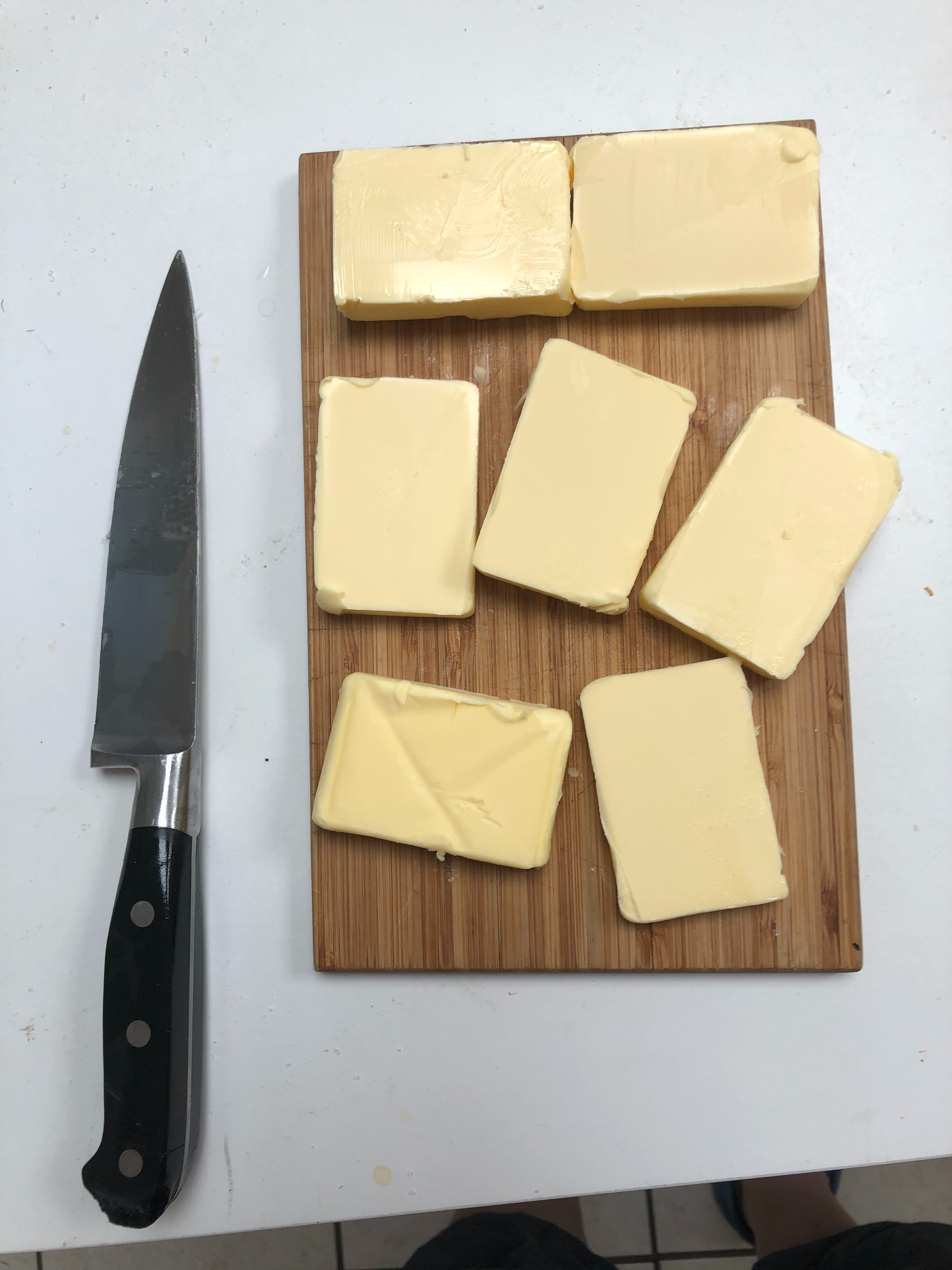 knife next to chopping board with slices of butter