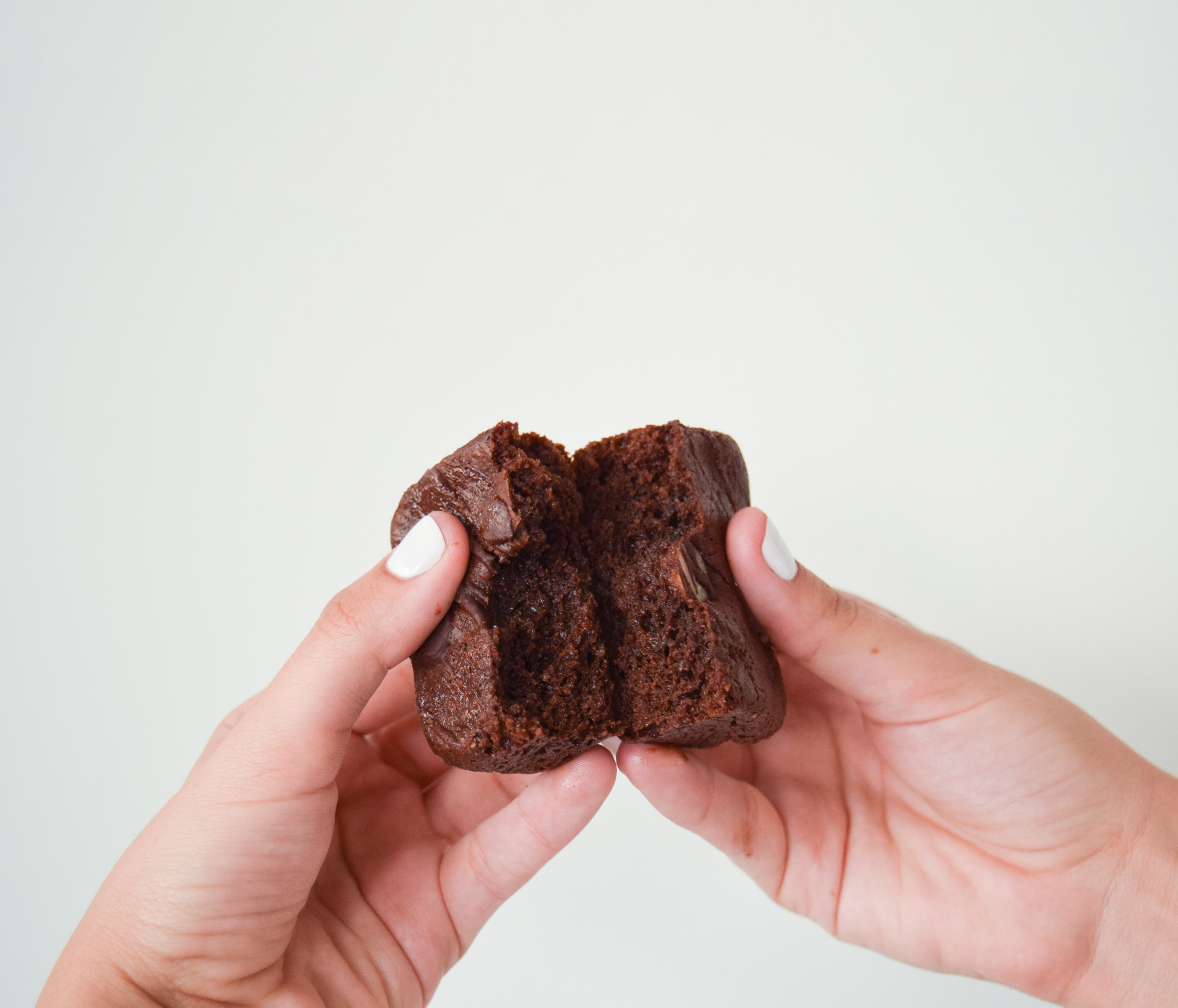 two hands splitting a brownie in half