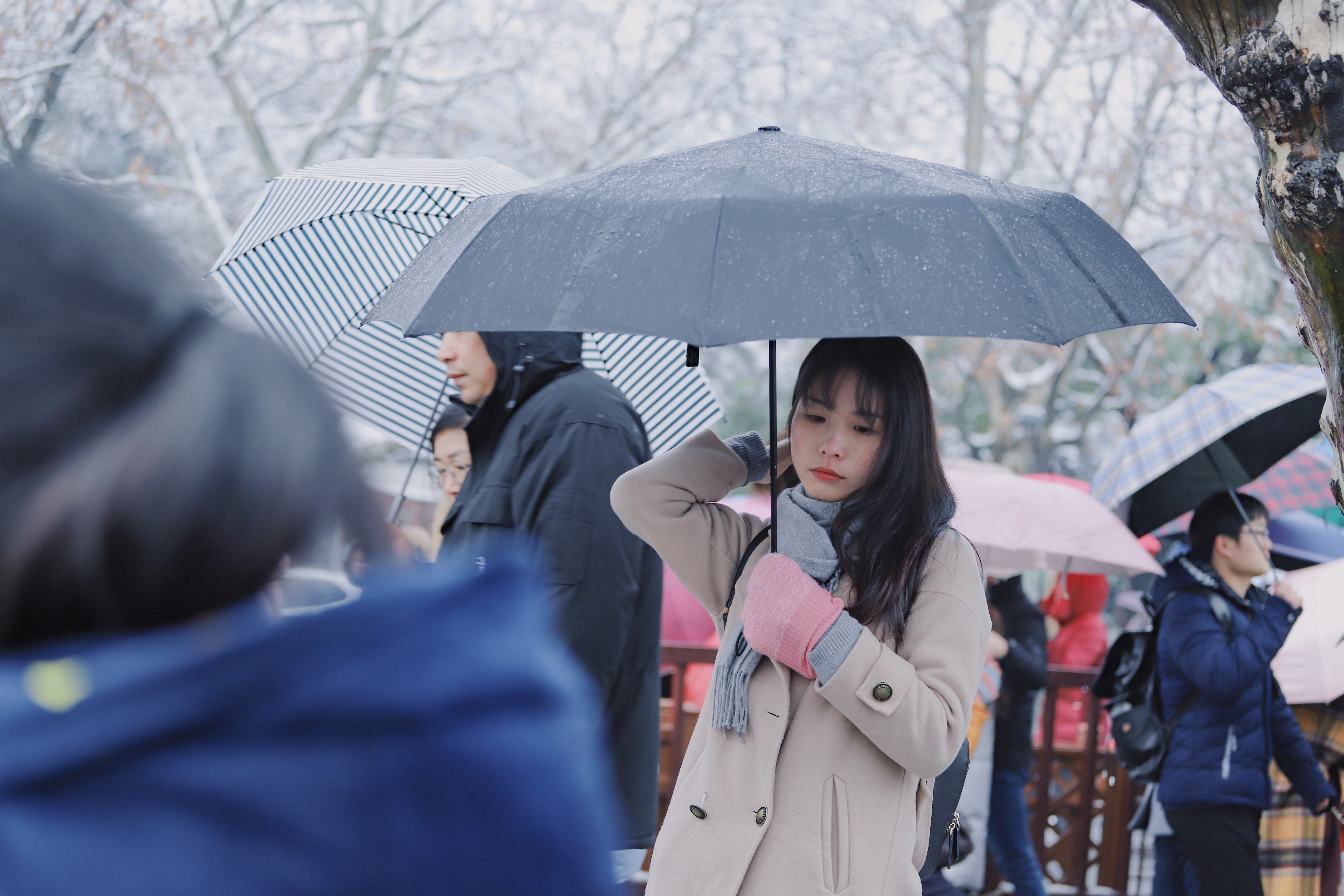 several people with coats and umbrellas